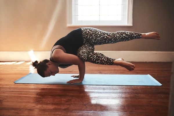 Control comes from your core and your mind. a young woman practising yoga at home