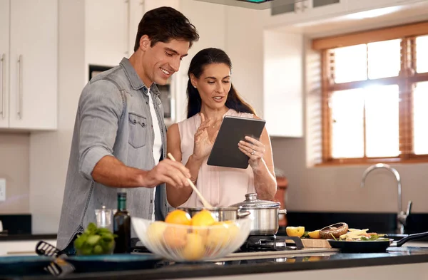 Ill read out the recipe for you. a young couple cooking together at home