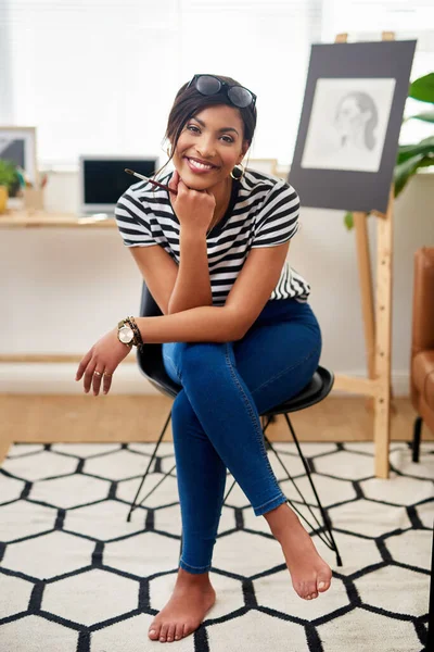 Start showing the world your creative side. Portrait of an attractive young artist smiling and feeling cheerful while sitting inside her studio at home