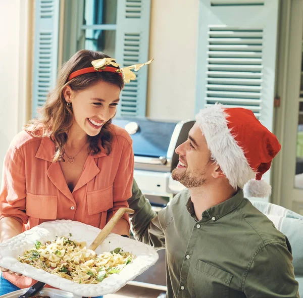 Good food and the perfect company to go with it. a beautiful young couple dishing up food together at a Christmas lunch party