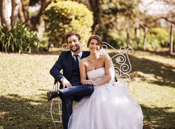 Were so happy we finally tied the knot. Cropped portrait of an affectionate newlywed couple smiling while sitting outdoors on their wedding day