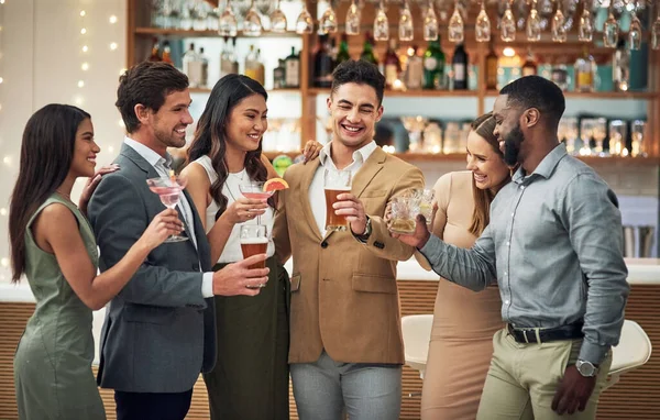 I want us to make a toast guys... a group of young friends preparing to make a toast with their drinks in a bar