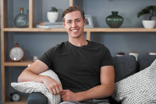 Being at home makes me happy. Cropped portrait of a handsome young man sitting on the sofa alone during a relaxing day at home