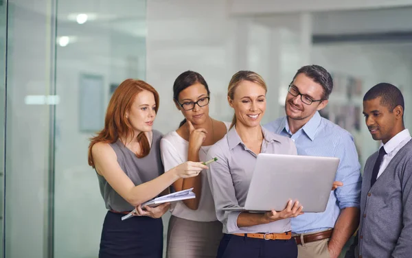 Manager with laptop showing, training or presenting strategy ideas or brainstorm plans with diverse group of office colleagues. Confident, smiling or happy leader updating team of staff on technology.