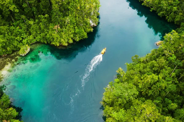 Set sail and discover new worlds of adventure. High angle shot of a boat sailing through a canal running along the Raja Ampat Islands in Indonesia