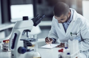 Scientist, researcher and medical technician writing on a tablet, recording information and results in a lab. Focused and serious worker using technology for innovation and research in a laboratory.