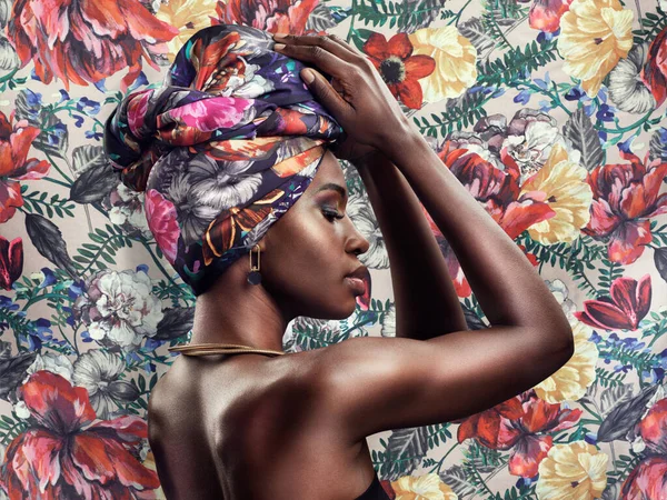 Fashion should make you feel fabulous. Studio shot of a beautiful young woman wearing a traditional African head wrap against a floral background
