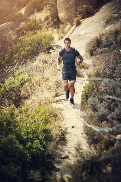Hiking is good for the body and mind. Full length shot of a handsome young man running during his hike in the mountains