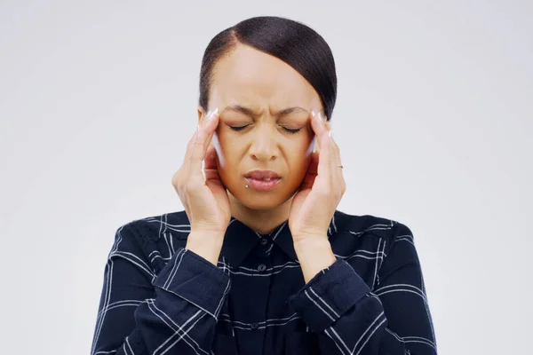 My brain cant take it anymore. a young woman holding her head while suffering from a headache against a grey background