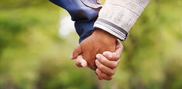 Hand in hand through it all. Closeup shot of an unrecognizable senior couple holding hands in the park