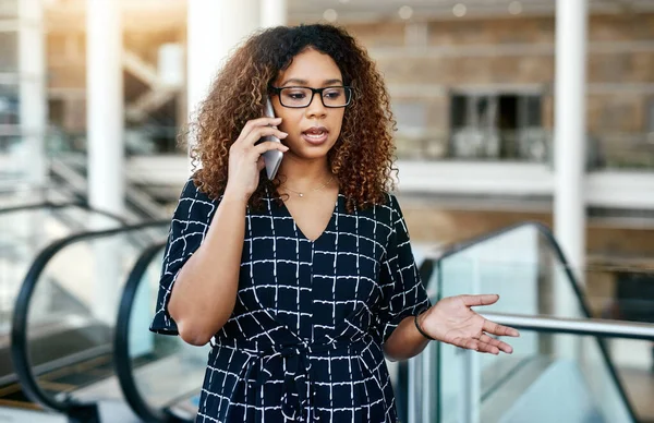 She knows the right things to say to win the deal. an attractive young businesswoman taking a phonecall while walking through a modern workplace