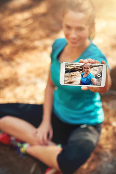 Selfies are better when out in nature. a sporty young woman using her cellphone while out in nature