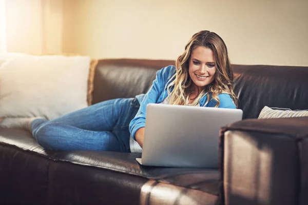 Make more time for yourself. a relaxed young woman using a laptop on the sofa at home