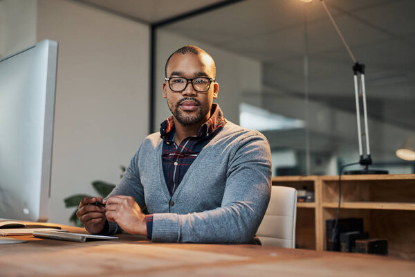 Hes not playing any games about his business. Portrait of a focused young businessman working in his office