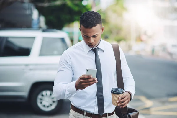 He does business on the move. a handsome young businessman using a cellphone in the city
