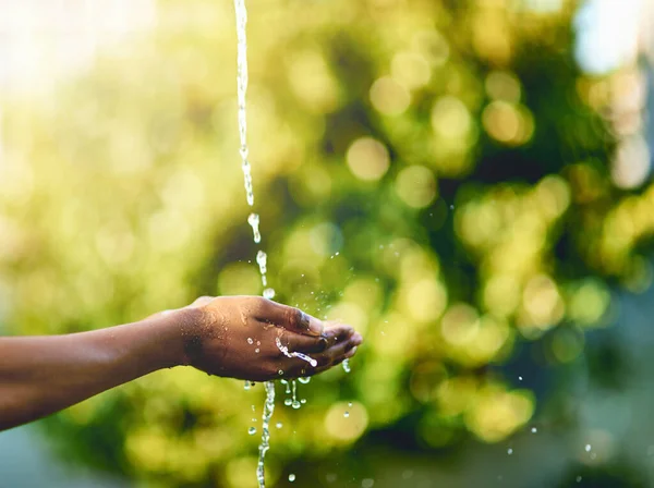 Closeup of hands catching fresh water outdoors, having fun in nature and practicing good hygiene. Person washing their fingers in a clean stream, enjoying splashing and refreshing germ free hydration.