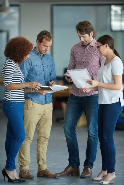 A diverse group of business people talking in a meeting at an office. Serious, ambitious and professional work team of colleagues discussing and planning a marketing strategy at a startup company.