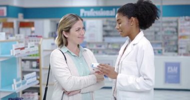 A young pharmacist explaining medical treatment to a woman in a modern drugstore. Guiding, assisting with the best health care advice and option. Worker providing great customer service at a pharmacy.