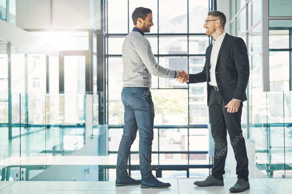 Handshake, teamwork and working together with corporate business men and colleagues at work as a team. Making a deal during a meeting, greeting and coming to an agreement in a modern office.