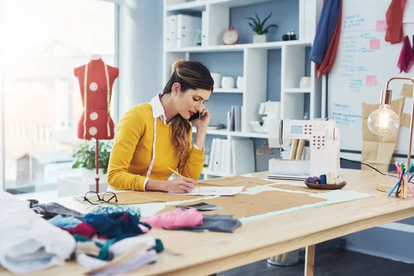 Tailor made success. an attractive young fashion designer in her workshop