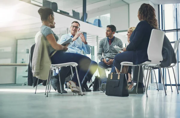 Teamwork, collaboration and strategy planning of business team working together indoors. Modern office workers talking and sitting in a group meeting. Colleagues work and talk about a project.