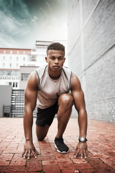 Start the day by fueling up on your fitness goals. Portrait of a sporty young man exercising outdoors
