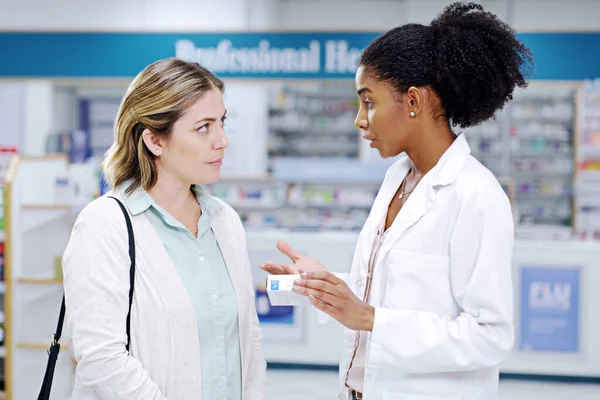 We prioritise helping you make better health choices. a young pharmacist recommending a health care product to a young woman at a pharmacy