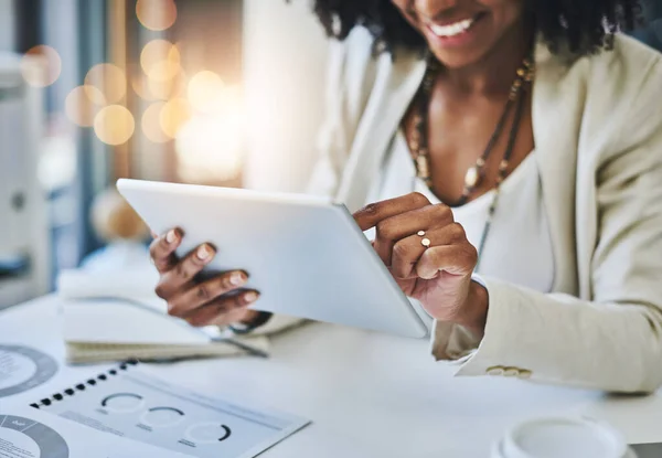 Change your world with the touch of a button. an unrecognizable businesswoman using her digital tablet at her office desk