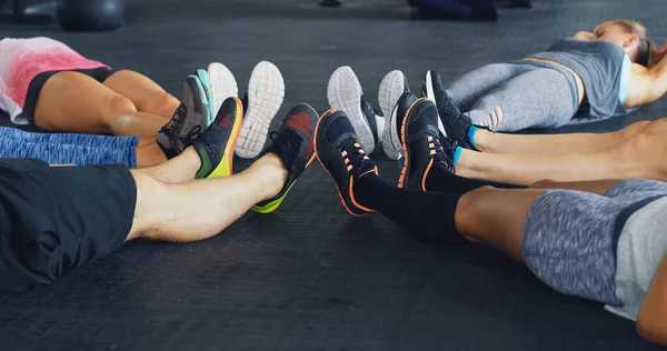 Friends dont let friends skip leg day. a group of people lying together in a circle during their workout at a gym