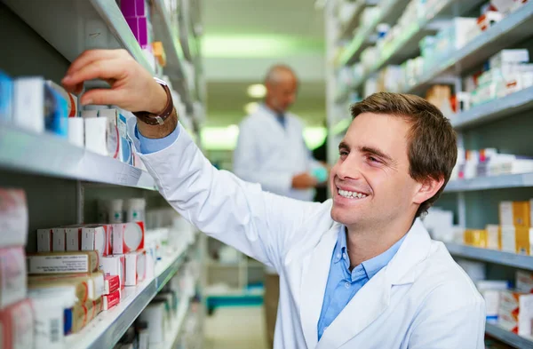 Stocking the best products to keep you feeling your best. a young pharmacist doing inventory in a pharmacy