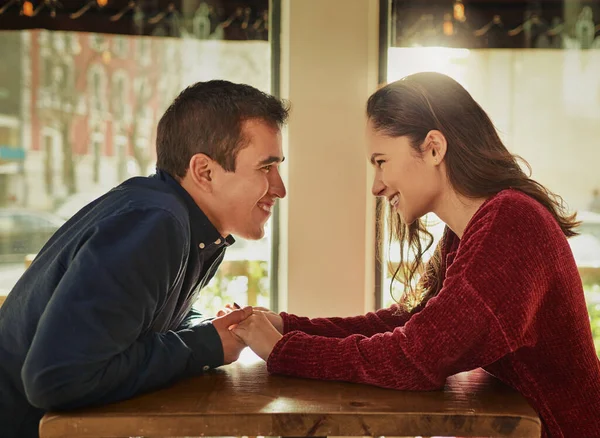 Can I kiss you. a young man and woman on a romantic date at a coffee shop