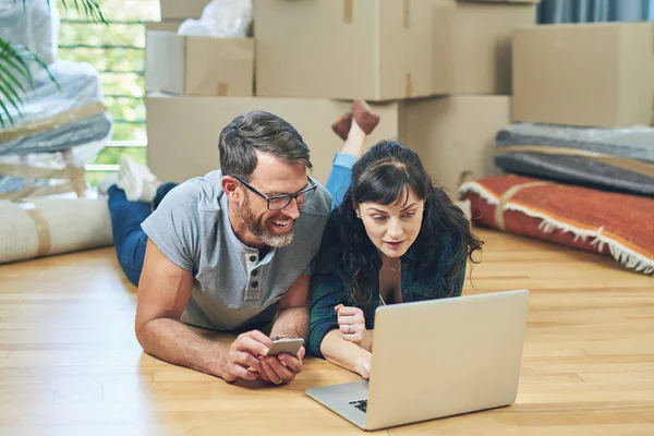 An easy moving day is a planned out one. a husband and wife using a laptop together on moving day