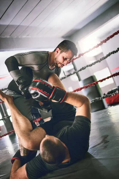 Countering is what its all about. two young male boxers facing each other in a training sparing match inside of a boxing ring on the floor at a gym during the day