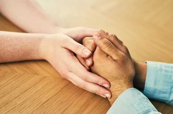 Nothing heals like the human touch. a man and woman holding hands in comfort on a table