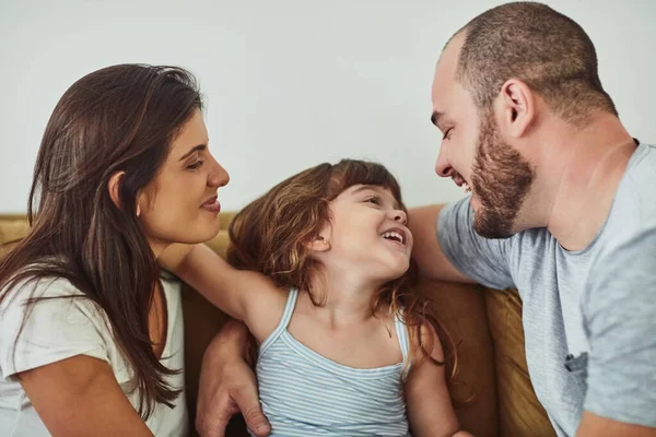 Family - make time, spend time. a mother and father bonding with their adorable young daughter at home