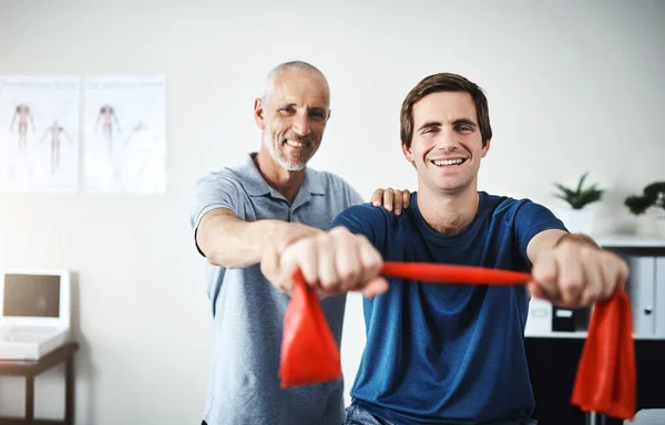 Physiotherapist Helping Patient Stretch Resistance Bands — Stockfoto