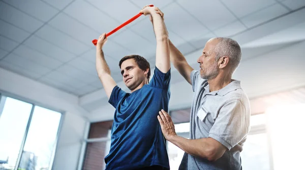 Theres Reason Make Your Injuries Impediment Physiotherapist Helping Patient Stretch — Fotografia de Stock