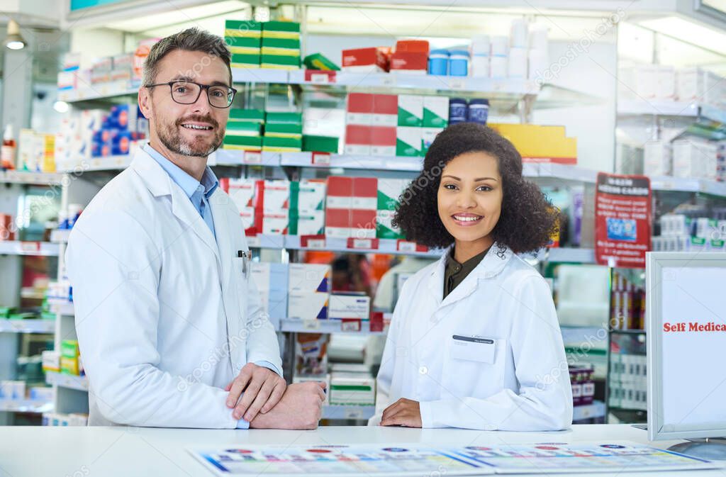 Your friendly neighbourhood pharmacists ready to take care of you. Portrait of a confident mature man and young woman working together in a pharmacy