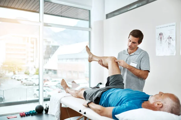 Taking Easy Today Young Male Physiotherapist Helping Client Leg Exercises — Stock Fotó