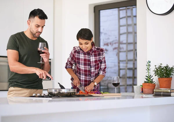 She has made me a better cook. a young attractive couple cooking together in the kitchen at home