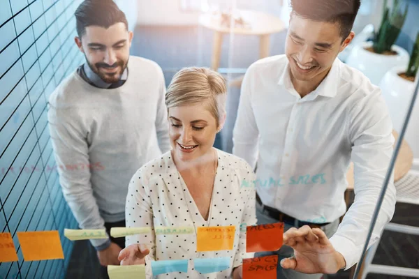 Theyre Making Progress Three Young Businesspeople Brainstorming Sticky Notes Glass — Zdjęcie stockowe