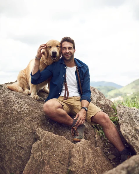 Mans best friend for life. a handsome young man sitting on a rock with his golden retriever after a day out hiking