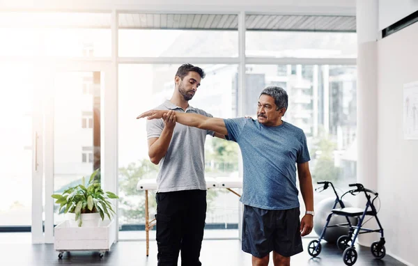 Stretch Far You Can Young Male Physiotherapist Helping Mature Male — Stockfoto