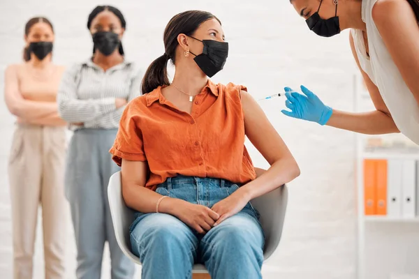 Vaccine, injection and medicine treatment for covid, flu and pandemic disease with nurse, healthcare or medical professional. Stylish, edgy and creative office woman with mask getting injected in arm.