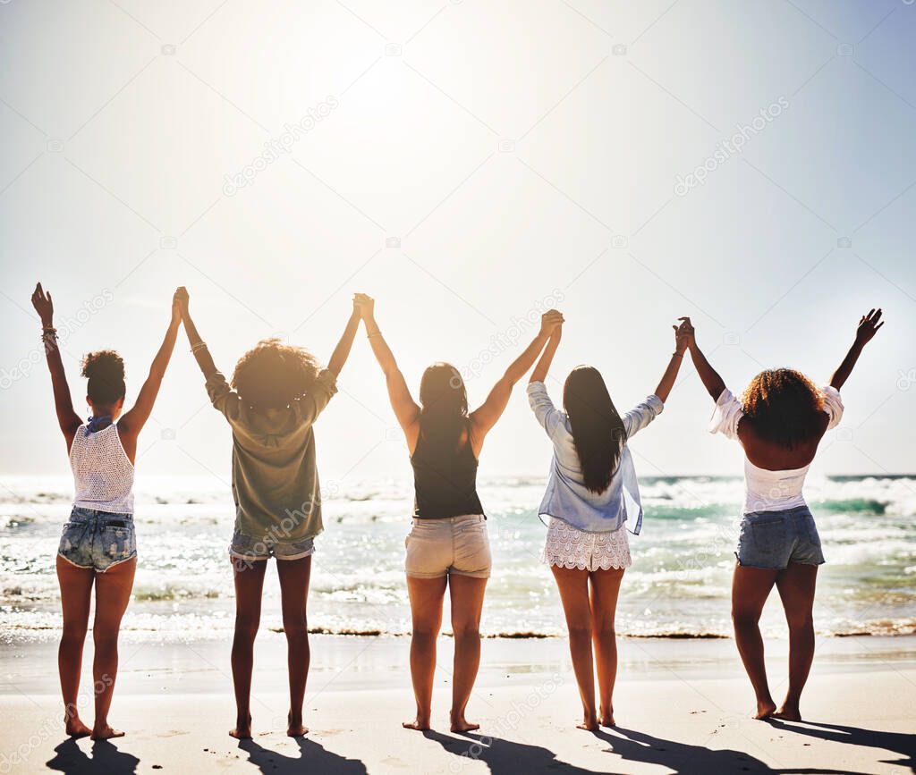Because beach days is what we live for. Rearview of a group of girlfriends holding hands in solidarity