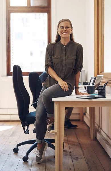 Creative startup entrepreneur and leader, motivation and inspiration for young females. Happy caucasian business woman and owner of consulting agency you can trust, sitting and smiling on work desk