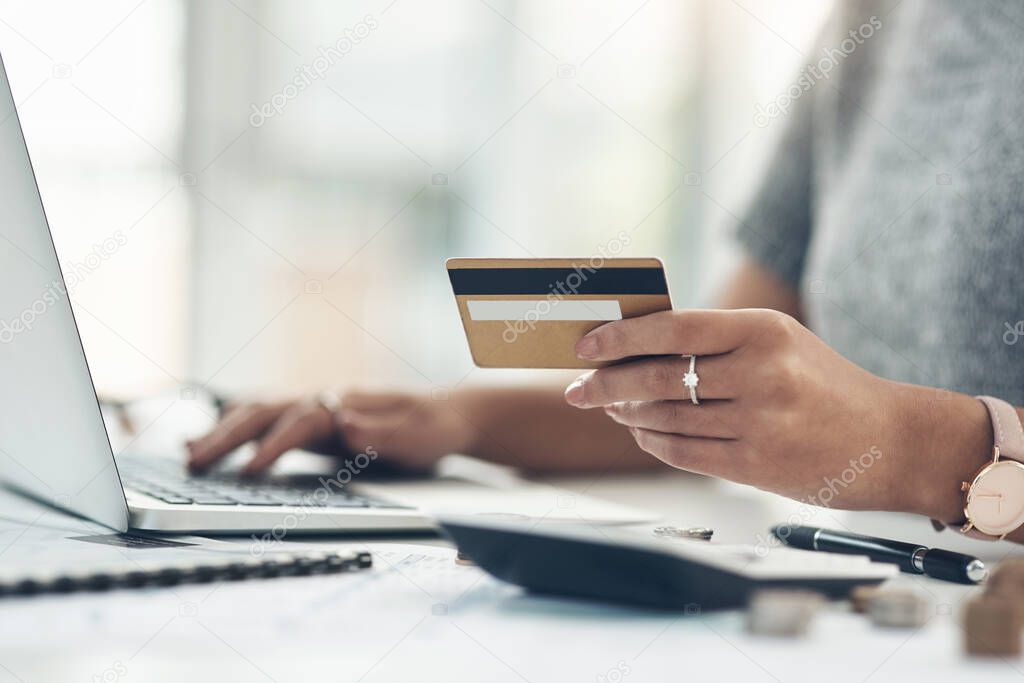 Banking, payment and paying bills online with ebanking on a laptop with a credit or debit card. Closeup of a woman doing online shopping during inflation. Female making payment for debt and mortgage