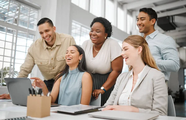 Cheerful, joyful professional business people looking at laptop, browsing funny videos online and bonding on break in office at work. Corporate, diverse and young colleagues searching the internet.
