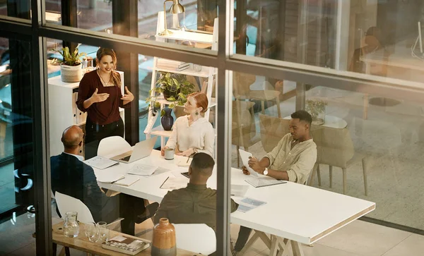 Team of business people meeting to discuss ideas, vision and strategy for project in a marketing agency. Leader and manager coaching a group of colleagues during a presentation in an office boardroom.