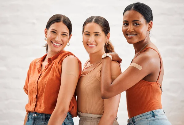 Covid vaccination or flu shot inside of girl friends, female friendship and teenagers smiling. Portrait of a happy and diverse friend group standing and practicing good health habits together.